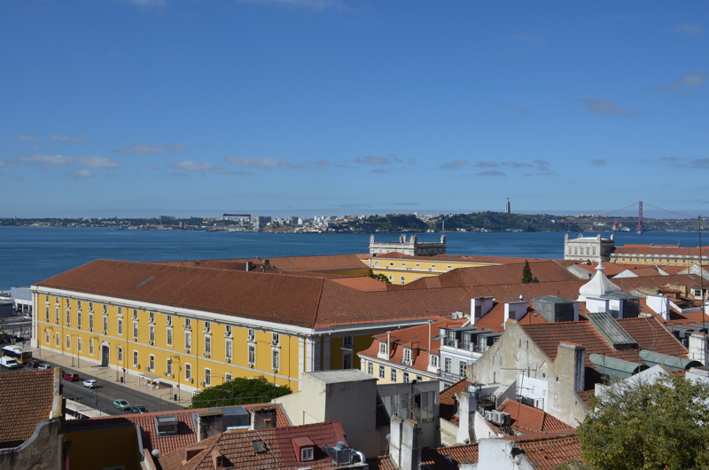 30 - View over the historic downtown of Lisbon, Portugal, featuring the prominent yellow wings of the Praça do Comércio buildings alongside the Tagus River
